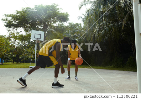Happy friends playing streetball on outdoor court Happy friends playing streetball on outdoor court 112506221