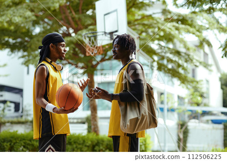 Cheerful friends talking after game of streetball Cheerful friends talking after game of streetball 112506225