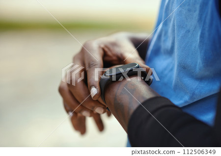 Closeup mage of sportsman checking fitness tracker after game of streetball 112506349
