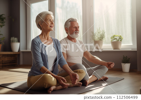 Elderly man and woman enjoy a peaceful yoga session in a sunny room 112506499