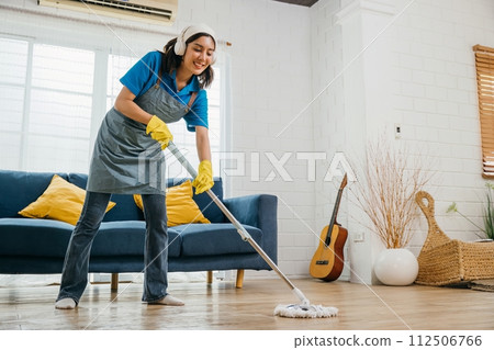 Asian teenager lively cleanup, maid listens dances sings using headphones. Joyful occupation with music excitement. Modern cleaning tech-driven fun. Give me melody, Happy and Fun During Cleaning Asian teenager lively cleanup, maid listens dances sings using headphones. Joyful occupation with music excitement. Modern cleaning tech-driven fun. Give me melody, Happy and Fun During Cleaning 112506766