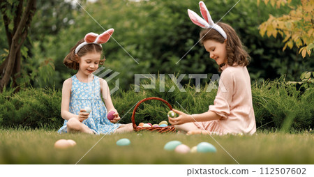 children with painting eggs outdoors 112507602