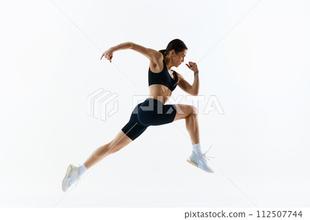 Dynamic image of young woman with strong, healthy, sportive body in sportswear in motion, training isolated over white studio background Dynamic image of young woman with strong, healthy, sportive body in sportswear in motion, training isolated over white studio background 112507744