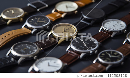A collection of stylish wristwatches, arranged in a pattern, showcases the elegance of timepieces 112508128