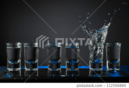 Alcoholic shots of vodka or strong drink in small glasses. 112508860