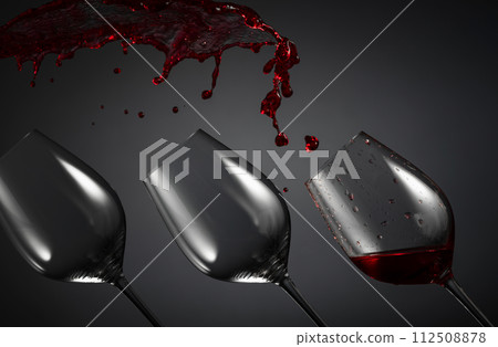 Empty wine glasses and red wine splashes on a dark background. Empty wine glasses and red wine splashes on a dark background. 112508878
