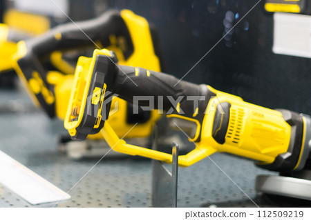 Power tools, drills and hammers of various manufacturers are sold in a hardware store. 112509219