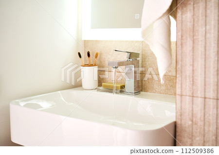 Bathroom sink with toothbrushes and running water. Bathroom sink with toothbrushes and running water. 112509386