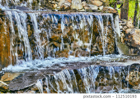 Pure mineral clean water flows over stepped mountain stones 112510193