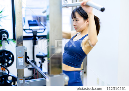 Woman working out at the gym, lat pulldown, female muscle training, workout 112510261