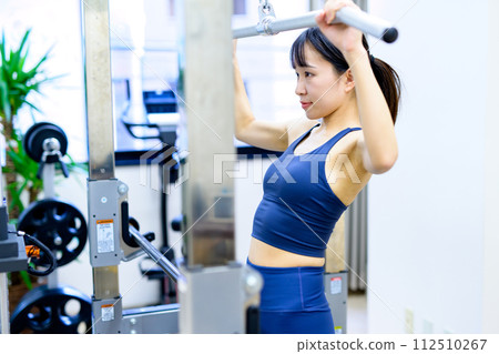 Woman working out at the gym, lat pulldown, female muscle training, workout Woman working out at the gym, lat pulldown, female muscle training, workout 112510267