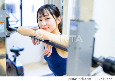 Portrait of a woman training her body at the gym Muscle training girl taking a break workout 112510366
