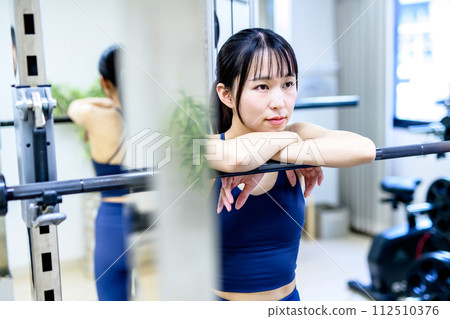 Portrait of a woman training her body at the gym. Muscle training girl taking a break. Workout clearly 112510376