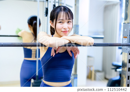 Portrait of a woman training her body at the gym Muscle training girl taking a break workout Portrait of a woman training her body at the gym Muscle training girl taking a break workout 112510442