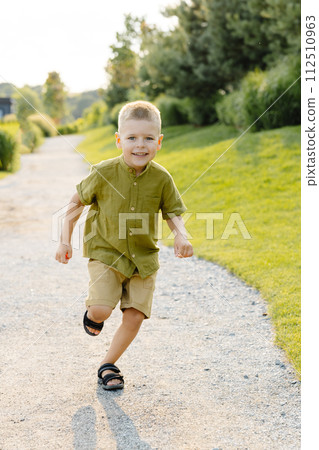 Young boy running down path 112510963