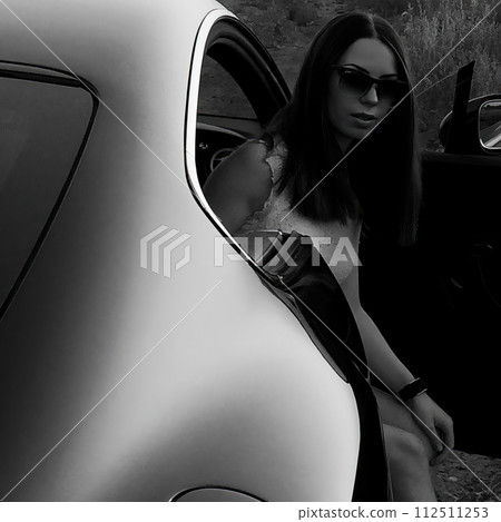 A relaxing moment when a beautiful woman sits in the front seat of a car and looks out the open door. Black and white image. AI-generated item A relaxing moment when a beautiful woman sits in the front seat of a car and looks out the open door. Black and white image. AI-generated item 112511253