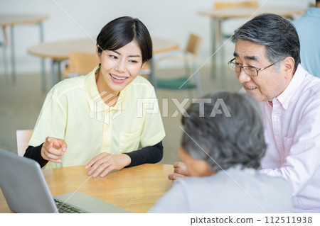 Senior couple receiving admission information Nursing home and senior couple Senior couple receiving admission information Nursing home and senior couple 112511938