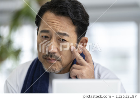 50多歲男子對著鏡子塗BB霜的男士化妝圖 112512187