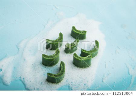 Soap with foam and aloe vera on blue background. Solid shampoo made from natural ingredients 112513004