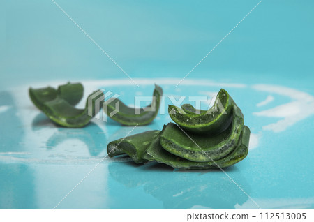 Soap with foam and aloe vera on blue background. Solid shampoo made from natural ingredients 112513005