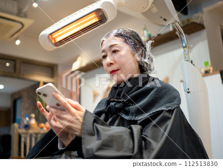 一位女士在美容院染白髮 112513830