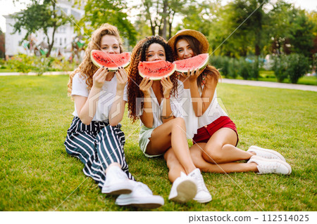 Three young woman have fun together and eating watermelon in hot summer day. Three young woman have fun together and eating watermelon in hot summer day. 112514025