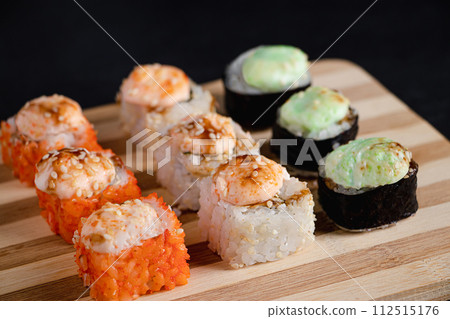 Set of sushi rolls on bamboo serving tray. Uramaki and futomaki roll 112515176