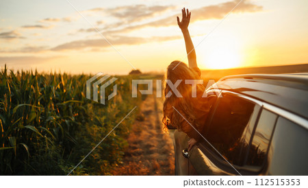 Young woman is resting and enjoying sunset in car. Lifestyle, travel, tourism, nature, active life. 112515353