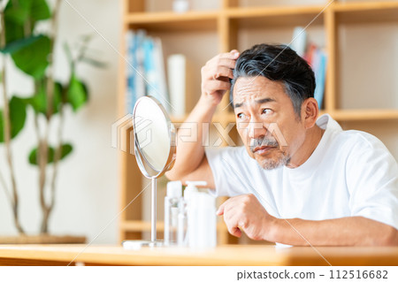 A middle-aged man who is concerned about his hair. A middle-aged man who is concerned about his hair. 112516682