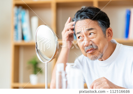 A middle-aged man who is concerned about his hair. 112516686