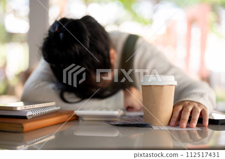 A disappointed and stressed Asian female small business owner is experiencing a financial crisis. A disappointed and stressed Asian female small business owner is experiencing a financial crisis. 112517431