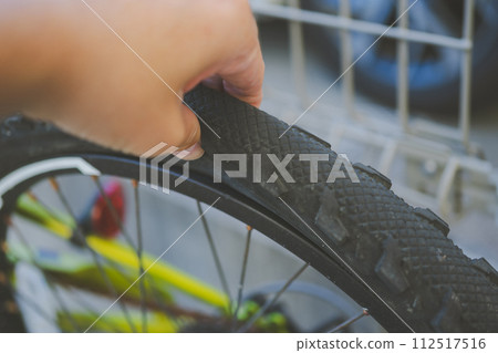 When I put my fingers between the sides of the bicycle tire and squeezed it, it dented, so I knew that the air was weak. 112517516