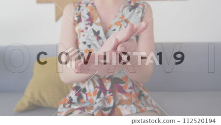 Image of multiple words flashing with woman disinfecting hands in office 112520194