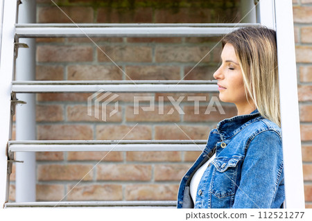 Urban Reflections: Casual Woman by the Brickwork 112521277
