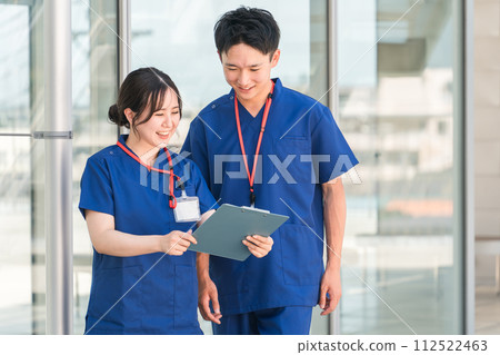 穿著手術服的男女檢查醫療記錄、材料和訂單 112522463