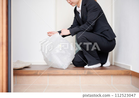 Business woman collecting trash at the entrance 112523047