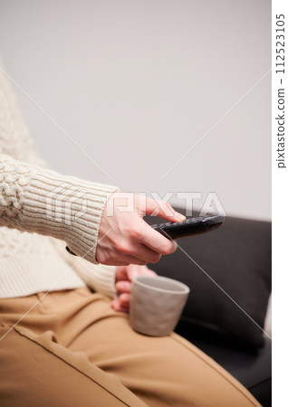 操作電視遙控器的女人 112523105