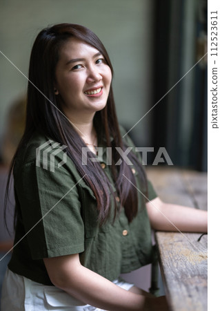 a portrait of beautiful happy asian woman traveler wearing brownish green dress stylish hipster Summer sunny lifestyle in coffee shop like the background 112523611