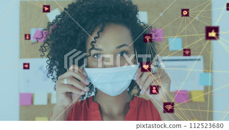 Image of net of connections with social icons with woman in office wearing face masks Image of net of connections with social icons with woman in office wearing face masks 112523680
