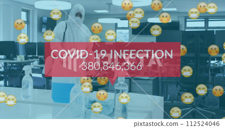 Image of word covid-19 and emojis floating with man disinfecting the office 112524046