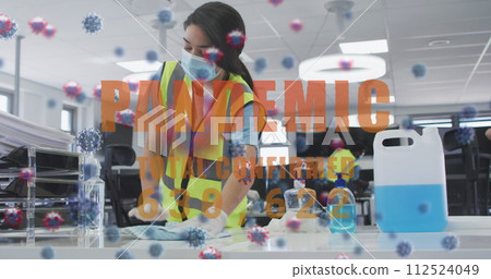 Image of word pandemic and covid-19 cells floating with work colleagues disinfecting the office 112524049