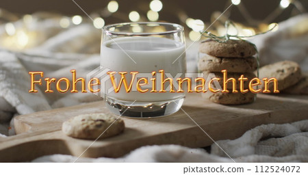 Frohe weihnachten text in orange over christmas cookies and milk with bokeh lights Frohe weihnachten text in orange over christmas cookies and milk with bokeh lights 112524072