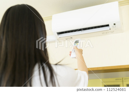 操作空調的女士（專注於遙控器） 112524081