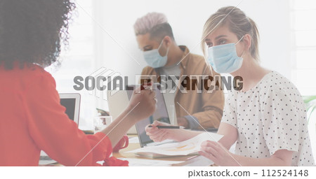 Image of words floating with colleagues in office wearing face masks 112524148