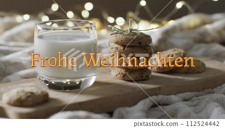 Frohe weihnachten text in orange over christmas cookies and milk with bokeh lights Frohe weihnachten text in orange over christmas cookies and milk with bokeh lights 112524442