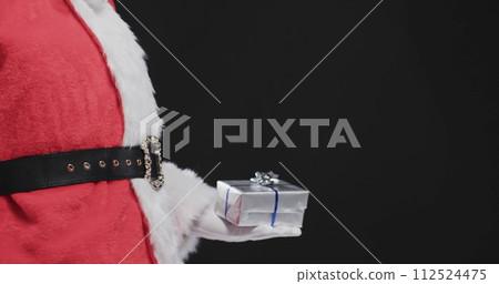 Santa Claus holds a small gift, with copy space Santa Claus holds a small gift, with copy space 112524475