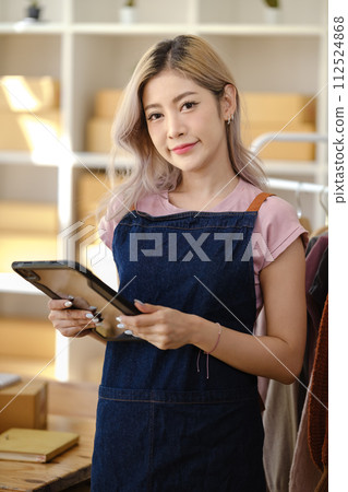 Portrait of young Asian woman SME working with a box at home the workplace.start-up small business owner, small business entrepreneur SME or freelance business online and delivery concept. 112524868