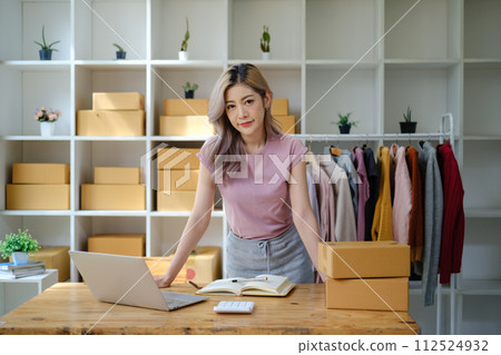 Portrait of young Asian woman SME working with a box at home the workplace.start-up small business owner, small business entrepreneur SME or freelance business online and delivery concept. 112524932