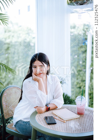 modern portrait of beautiful happy asian woman traveler wearing smartwatch wearing beautiful white dress and wear jeans lifestyle enjoying in sitting coffee shop restaurant background 112525476