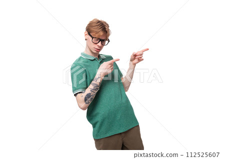 young caucasian man with red hair dressed in a green t-shirt smiling and joking against the young caucasian man with red hair dressed in a green t-shirt smiling and joking against the 112525607